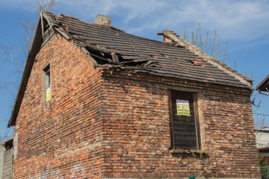 Terk edilmiş boş tuğlalı bir ev, mavi gökyüzüne karşı ve 