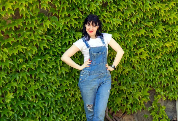 Middle Aged Woman Dark Haired Brunette Denim Overalls Stands Background — Stock Photo, Image