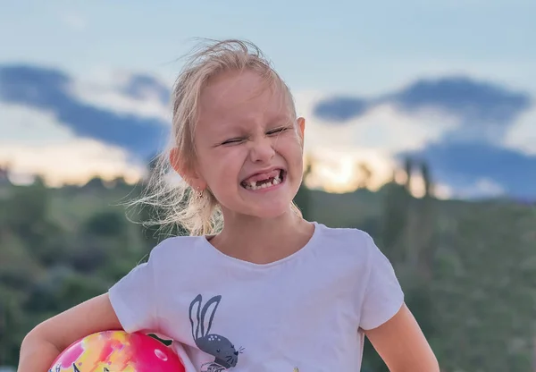 6歳の女の子は歯のない口で元気に笑って目を細めて子供の肖像画就学前の可愛い金髪で楽しそうに口を開けて — ストック写真