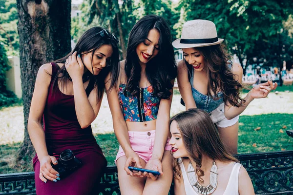 Fyra vackra unga flickor tittar på bilderna — Stockfoto