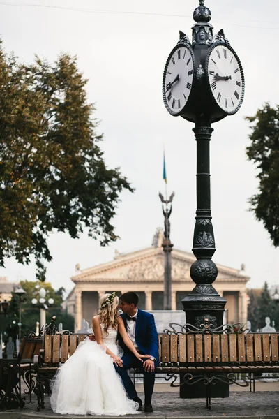 Bröllop par kopplar av på en bänk — Stockfoto