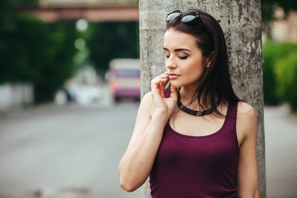 Mooi meisje zit in een stad straat — Stockfoto