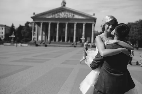 Groom holds bride in his arms and twisted — Stock Photo, Image