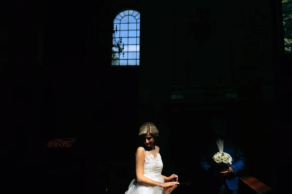 Bride and groom illuminated by light — Stock Photo, Image