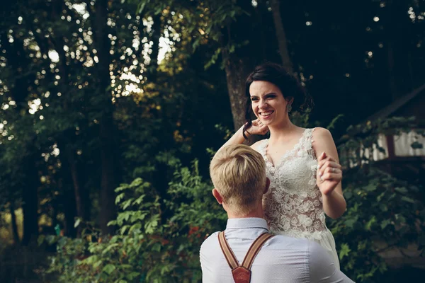 Brudgummen har bruden i armarna — Stockfoto