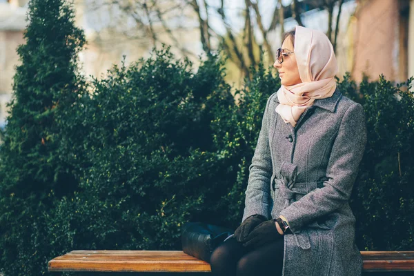 Mädchen sitzt auf einer Bank im Park — Stockfoto