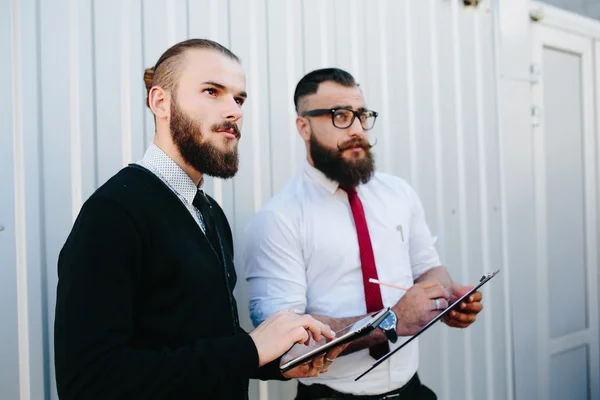 Два бородатых бизнесмена смотрят на что-то — стоковое фото