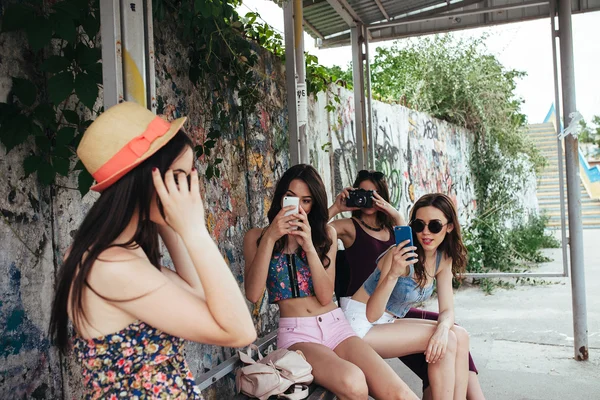 Cuatro hermosas chicas en la parada de autobús — Foto de Stock