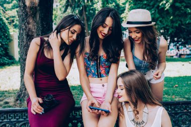 dört güzel genç kızlar fotoğraflarına bakmaktan