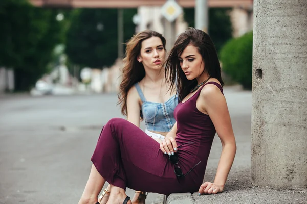 Twee mooie jonge meisjes poseren in de stad — Stockfoto