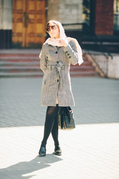Meisje in een jas aan de straat — Stockfoto