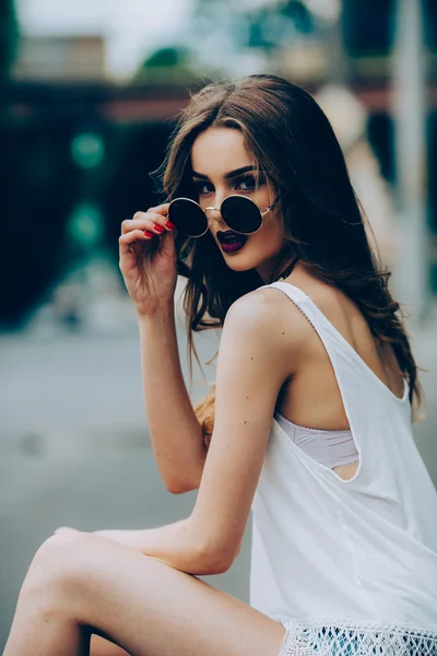Güzel kız oturan güneş gözlüğü — Stok fotoğraf