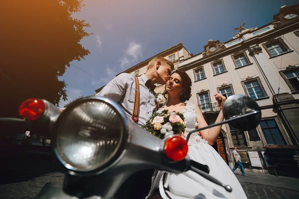 Жених и невеста на винтажном мотороллере — стоковое фото