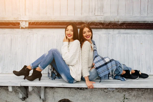 Duas meninas sentam-se em um banco no parque — Fotografia de Stock