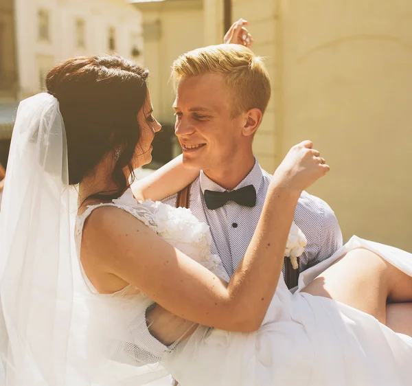 Damat gelin onun kollarında taşır. — Stok fotoğraf