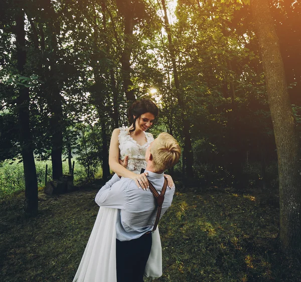 De bruid bruidegom opgeheven in zijn armen — Stockfoto