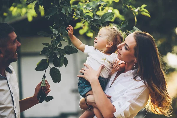 Famílias com uma criança no jardim de verão — Fotografia de Stock