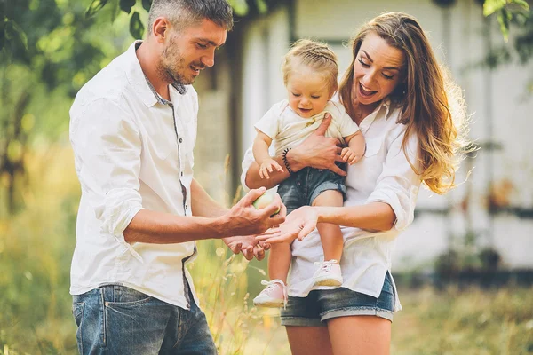 Familjer med ett barn i sommarträdgården — Stockfoto