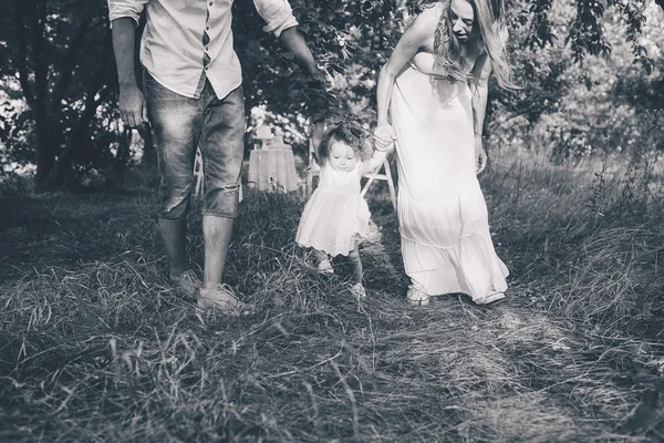 Mladá rodina chůzi v zahradě — Stock fotografie