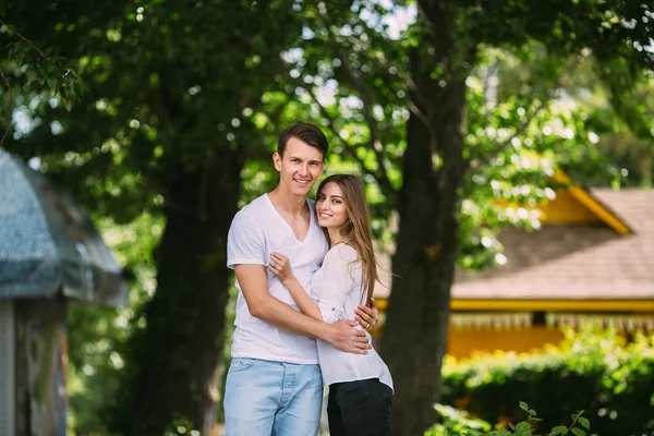 Young adult brunette man and woman in the park — Stock Photo, Image