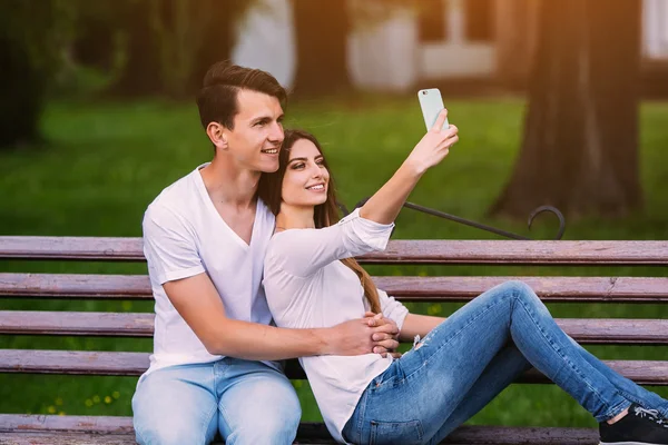 Homem e mulher em um parque fazer selfie — Fotografia de Stock