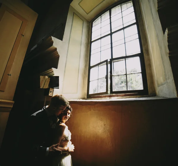 Bride and groom on the background of a window. — Stock Photo, Image