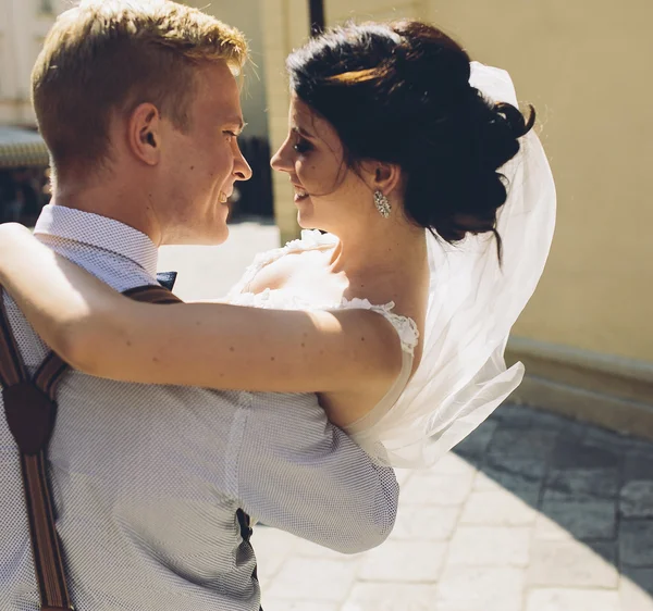 Novio lleva novia en sus brazos — Foto de Stock