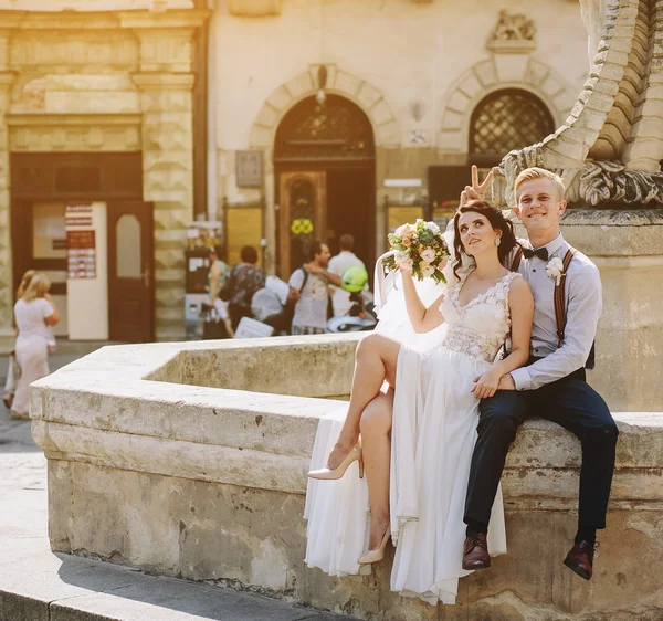 Mariée et marié posant à la fontaine — Photo