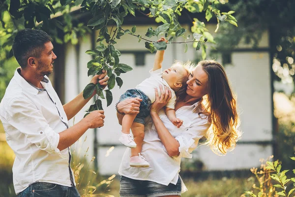 Familjer med ett barn i sommarträdgården — Stockfoto