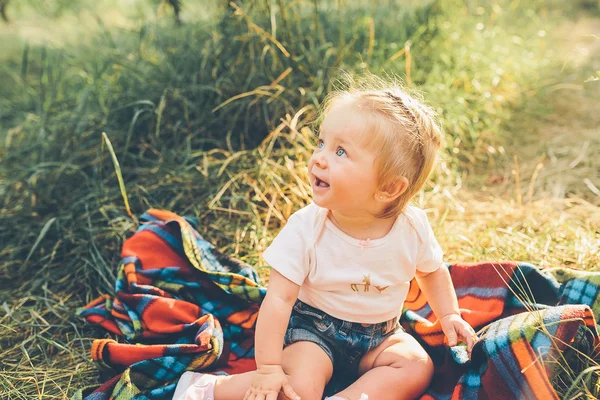 Malá dívka sedící na trávníku — Stock fotografie