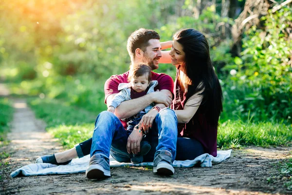 Jovem família com uma criança na natureza — Fotografia de Stock