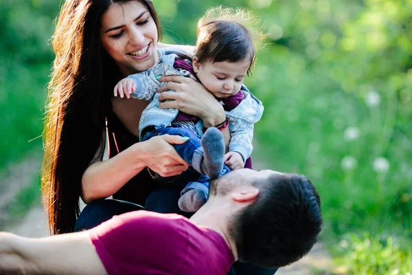 Jovem família com uma criança na natureza — Fotografia de Stock