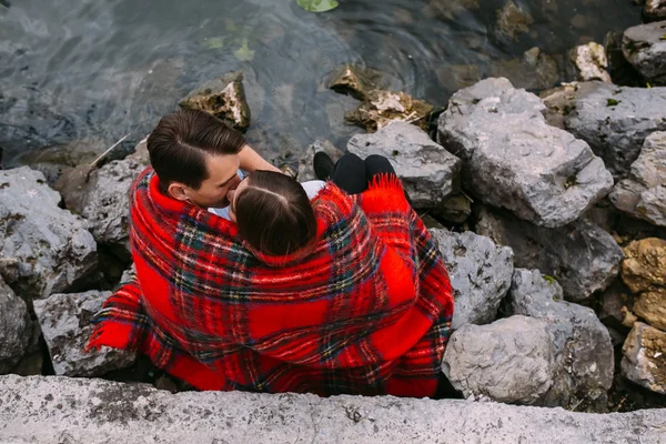 Unga vackra paret sitter på stranden — Stockfoto