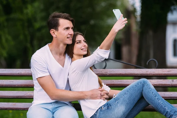 Muž a žena v parku, aby selfie — Stock fotografie