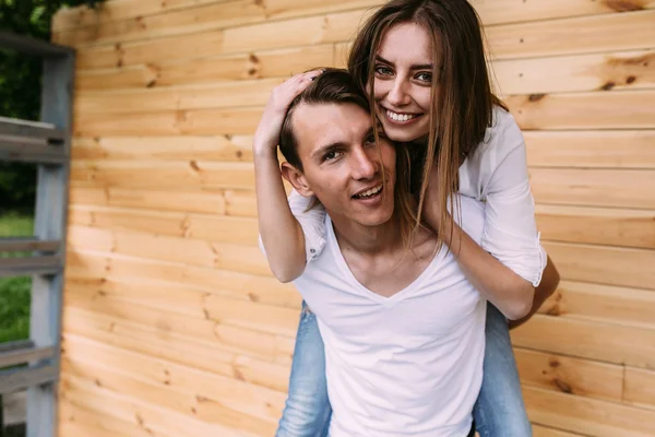 Casal posando em um fundo da parede de madeira — Fotografia de Stock