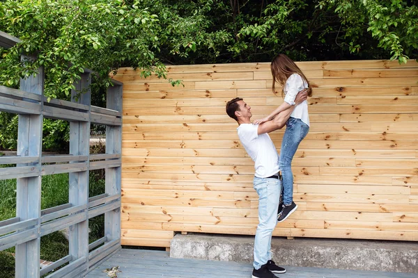 Casal posando em um fundo da parede de madeira — Fotografia de Stock