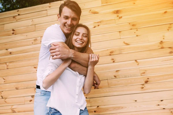 Couple posing on a background of the wooden wall — Stock Photo, Image