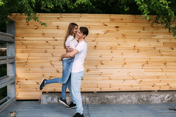 Couple posing on a background of the wooden wall — Stock Photo, Image