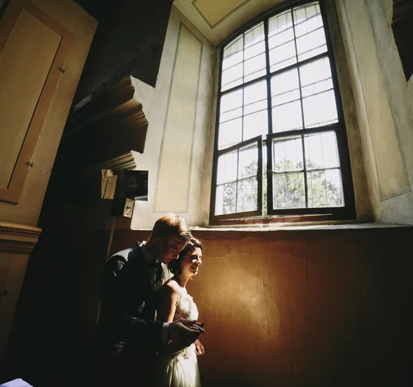 Bruden och brudgummen på bakgrunden av ett fönster. — Stockfoto