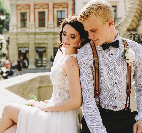 Bride and groom posing at the fountain — Stock Photo, Image