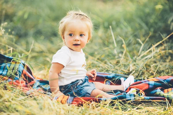 Маленькая девочка сидит на лужайке — стоковое фото