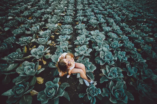 Mother and daughter on the field with cabbage — Stock Photo, Image