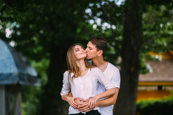 Young adult brunette man and woman in the park — Stock Photo, Image