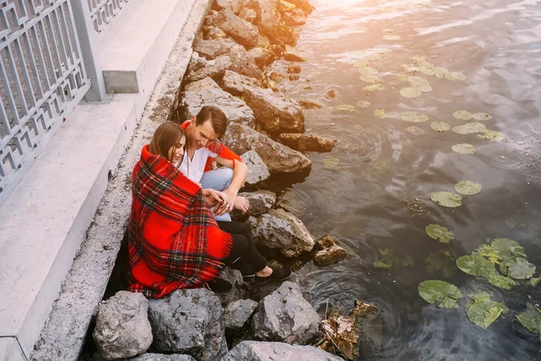 Unga vackra paret sitter på stranden — Stockfoto