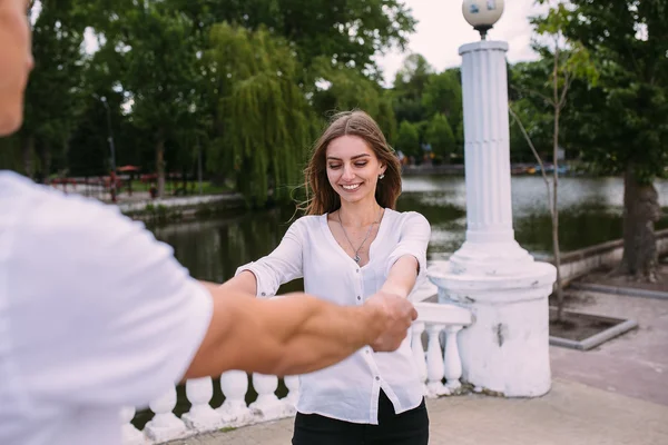 Casal se divertindo em uma ponte no parque — Fotografia de Stock