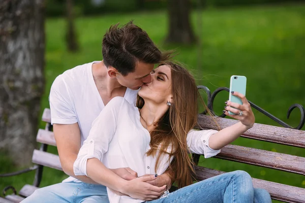 Muž a žena v parku, aby selfie — Stock fotografie