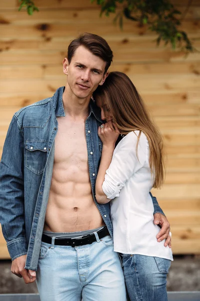 Couple posing on a background of the wooden wall — Stock Photo, Image