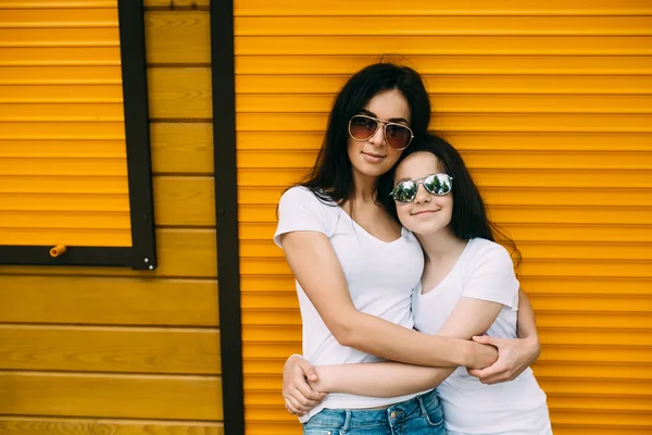 Mãe e sua filha bonito, contra a parede — Fotografia de Stock