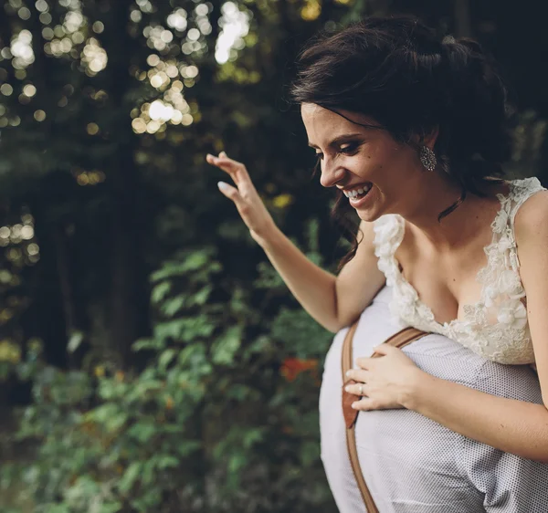 Groom holds bride in his arms — Stock Photo, Image