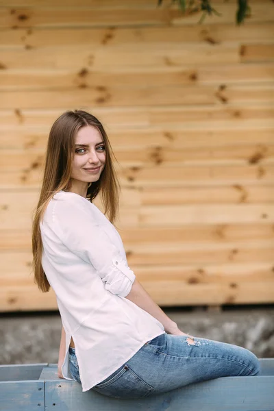 Mädchen posiert vor dem Hintergrund einer Holzwand — Stockfoto